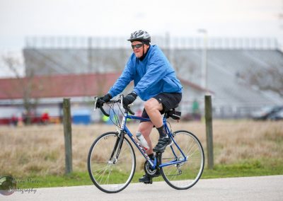 Vegan cyclist riding a bike in a park during daytime, showcasing eco-friendly transportation.
