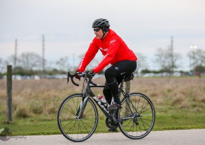 High-performance cyclist in red gear biking outdoors during daytime.