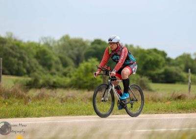 Vibrant cyclist riding a mountain bike on scenic Texas trail during daytime.