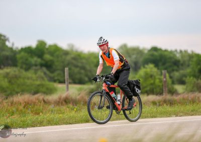 Rider on electric bike enjoying outdoor cycling on scenic trail with lush greenery.