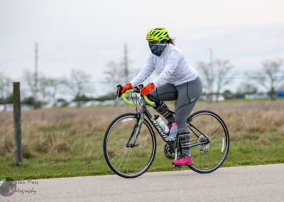 Bright yellow bike helmet, face mask, and athletic cycling attire for Bluebonnet Express event.