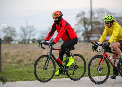 Colorful cyclists riding road bikes outdoors during daytime for Bluebonnet Express event.