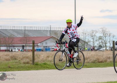 Bright cyclist wearing a colorful jersey with polka dots, riding a road bike during the Bluebonnet Express event.