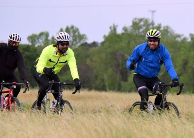 Vibrant cyclists enjoying a ride in an open field, showcasing outdoor biking adventure with safety gear.