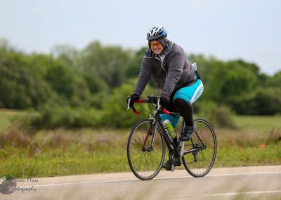 Bright male cyclist enjoying a ride on a scenic outdoor trail with Bluebonnet Express bike gear.