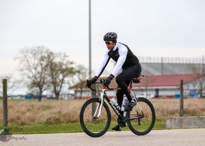 Cyclist riding a road bike outdoors during a cloudy day for Bluebonnet Express event.