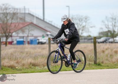Woman riding a mountain bike during the Bluebonnet Express cycling event outdoors.
