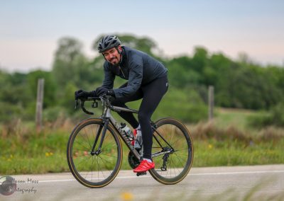Vibrant cyclist riding on scenic outdoor trail with Bluebonnet Express branding in background.