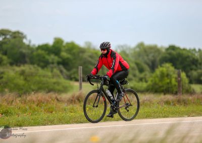 Bright red and black cycling jacket on a rider on Bluebonnet Express bike trail in Texas.