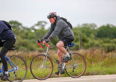 VINTAGE MAN ON ROAD BIKE RIDING THROUGH NATURE, promoting outdoor cycling adventures and fitness.