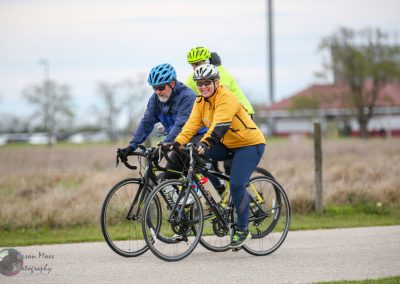 Brightly dressed cyclists enjoying a scenic ride on a clear day during Bluebonnet Express event.
