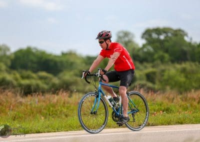 Bright red cyclist jersey on a scenic rural bike ride.