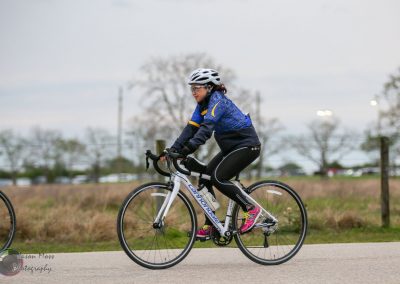 High-performance road bike in blue and black with a cyclist wearing helmet and sportswear, showcasing active cycling.