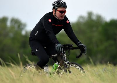 Brightly colored Bluebonnet Express bicycle with rider in outdoor cycling scene.