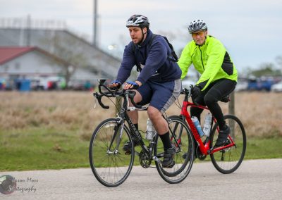 Collapsible bike on paved trail, two cyclists riding together, outdoor biking activity, Bluebonnet Express.