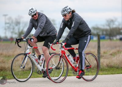 Two cyclists riding their bikes together along a scenic outdoor trail.