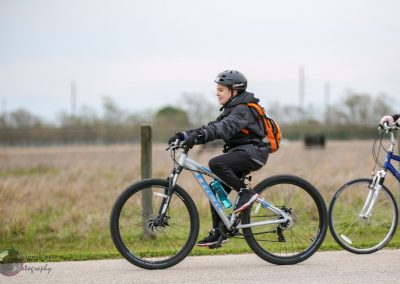 Child enjoying a scenic bike ride on a mountain trail with a Bluebonnet Express bike.