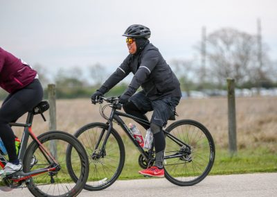 Bright cyclist enjoying Bluebonnet Express bike ride in outdoor setting, wearing safety gear and athletic clothing.