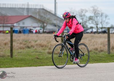 Woman cyclist riding on trail in athletic biking gear.