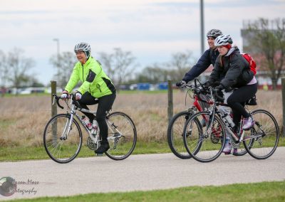 Bike riders enjoying a scenic outdoor trail in a park with fall foliage.