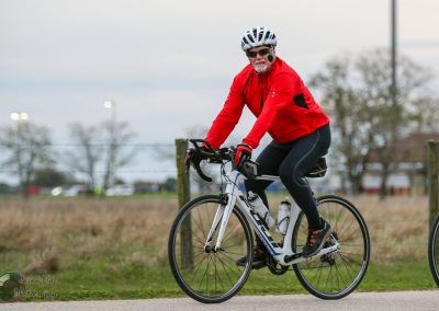 Vibrant cyclist riding a mountain bike outdoors with fall foliage in the background.