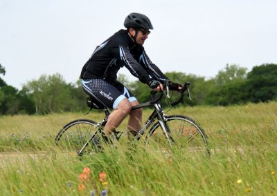 High-performance cyclist riding on scenic grassy trail, promoting outdoor biking adventures.