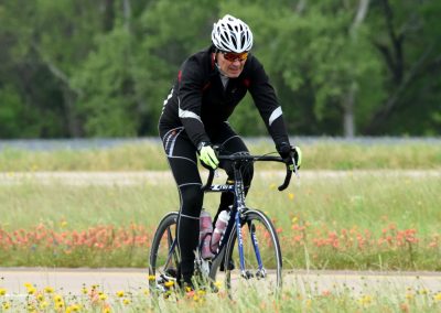 Vibrant cyclist riding through wildflowers on the Bluebonnet Express trail during spring.