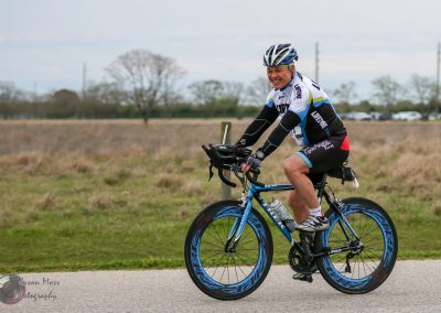 Vibrant cyclist riding a Bluebonnet Express bike during a community cycling event outdoors.