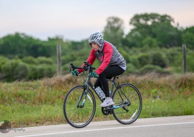 Bike rider on scenic outdoor trail with cyclist gear for Bluebonnet Express event.