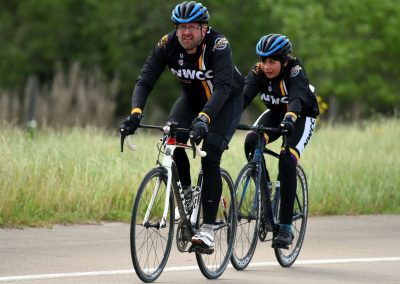 Active cyclists riding bicycles on a scenic outdoor trail, promoting health and fitness.