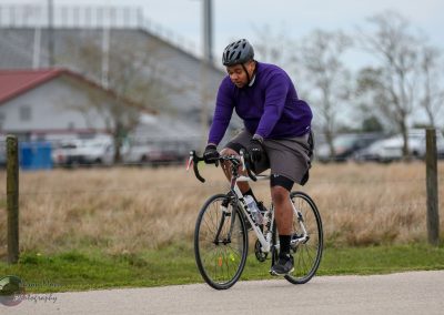 Ableist bicycle rider on road biking outdoors in weather.