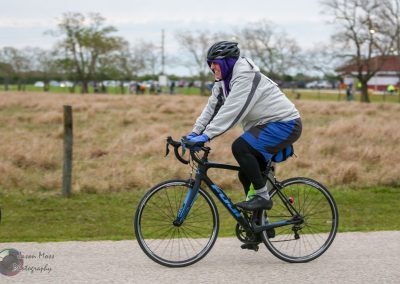 Bright blue and black bike riding outdoors during daytime, person in active cycling gear.