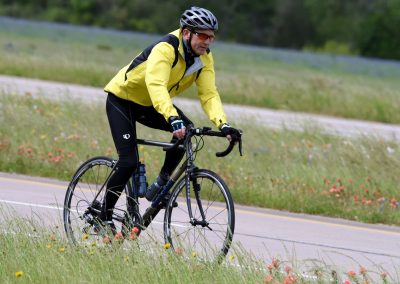 Vibrant cyclist riding through scenic rural landscape on a bike.