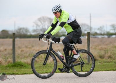 Velo cyclist riding on a paved trail, showcasing Bluebonnet Express biking experience.