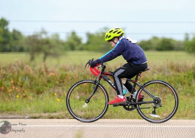 Child riding a mountain bike on a trail, promoting Bluebonnet Express bicycle tours and outdoor adventure.