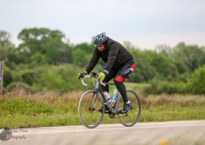Speedy cyclist riding on scenic rural road for Bluebonnet Express bike tour.