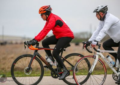 Vivid cyclist riding bikes outdoors with an overcast sky, emphasizing adventure and cycling freshness.