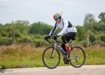 Cyclist riding a road bike outdoors, emphasizing eco-friendly transportation and fitness.