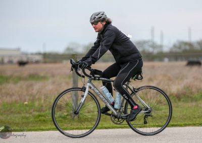 Rider on a Specialized hybrid bike cycling outdoors on a cloudy day.