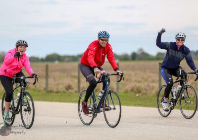 Brightly dressed cyclists enjoying a scenic ride on a clear day.