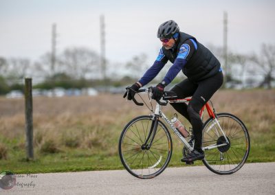 A cyclist riding a bike outdoors for Bluebonnet Express event, promoting cycling and eco-friendly transportation.