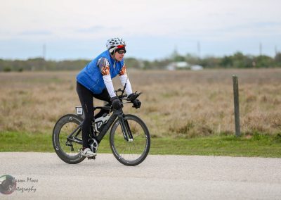 Bright female cyclist riding an e-bike on a scenic rural trail, promoting eco-friendly transportation.