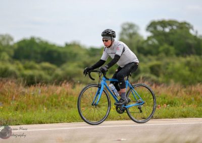Vibrant blue bike on scenic outdoor trail, cyclist enjoying a ride in nature.
