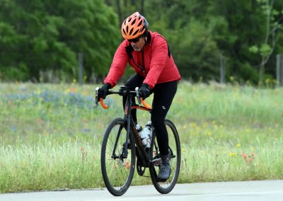 Bold, adventurous cyclist riding a bluebonnet express road bike in lush green outdoor setting.