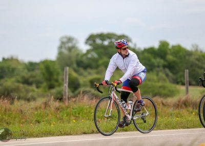 Cyclist riding on a rural road near Austin Texas, during the Bluebonnet Express event, promoting community and outdoor cycling activities.
