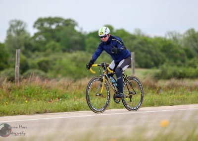 Cyclist enjoying a ride on the Bluebonnet Express bike route through scenic countryside.