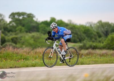 High-performance cyclist on a scenic rural road during daytime.