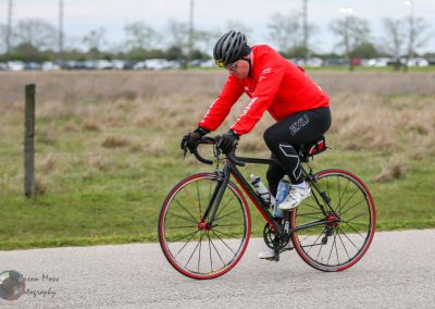 Rider on a black and red road bike during a cycling event, promoting Bluebonnet Express.