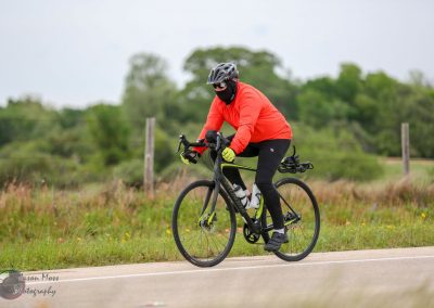 Electric bike rider on the Bluebonnet Express trail with scenic Texas countryside, promoting eco-friendly cycling.