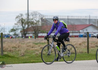 Colorful cyclist riding on scenic trail during daytime.